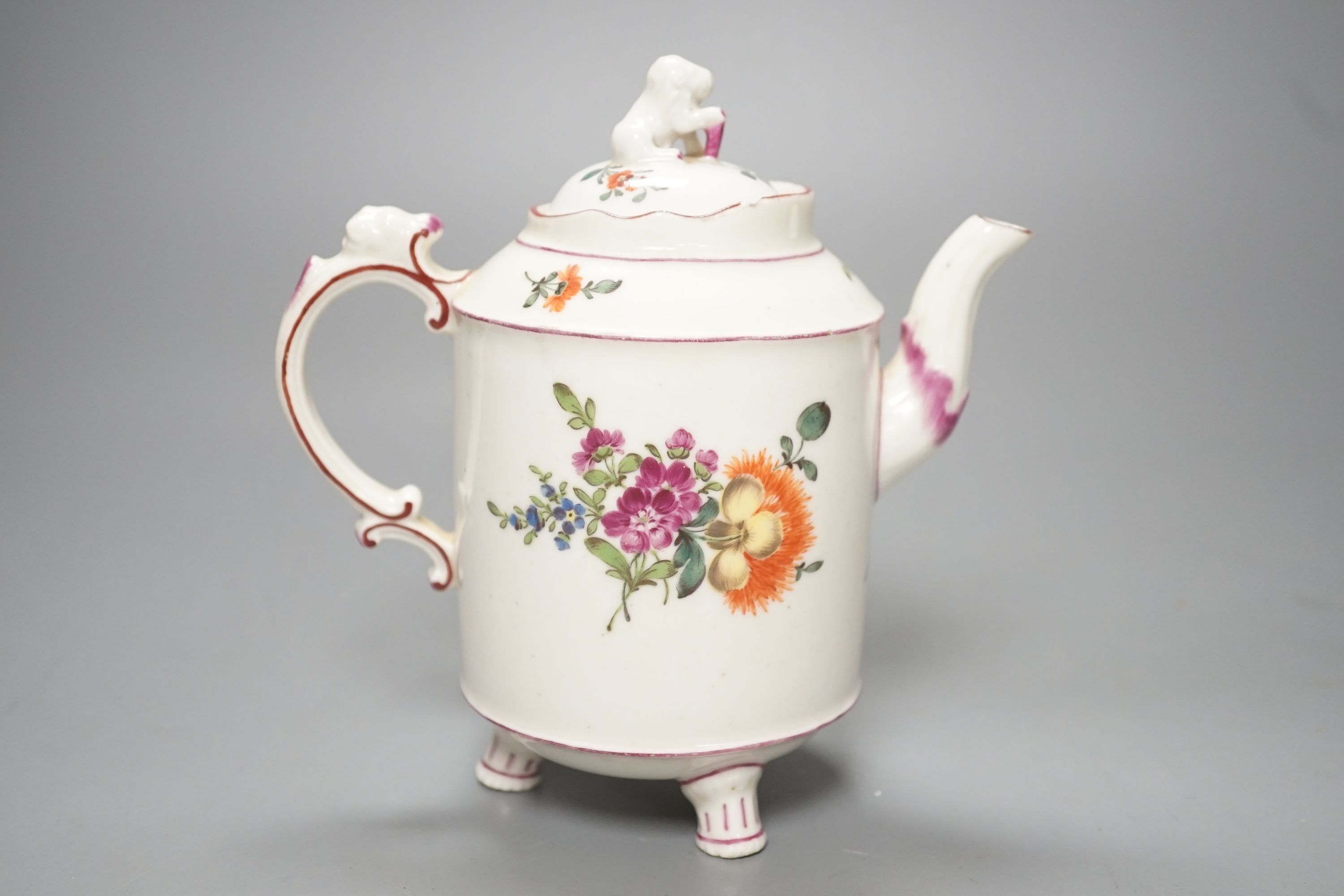 An 18th century Ludwigsburg three footed teapot and cover with lion finial and lion head on handle painted with flowers, height overall 16.5cm